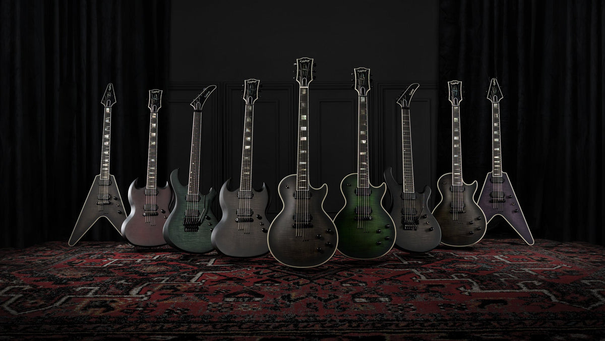 The Epiphone Prophecy Series lineup on a rug in a dark, curtained room