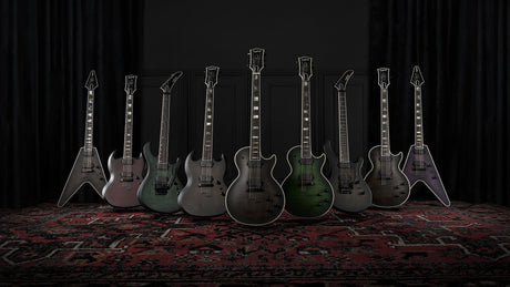 The Epiphone Prophecy Series lineup on a rug in a dark, curtained room