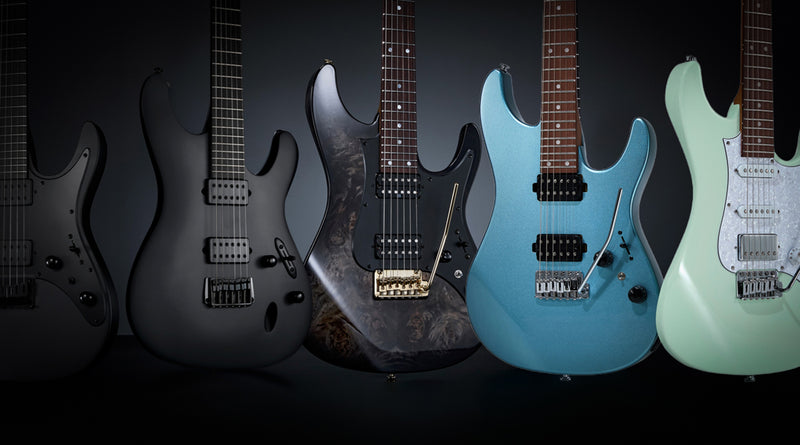 Five electric guitars in different colors on a black background